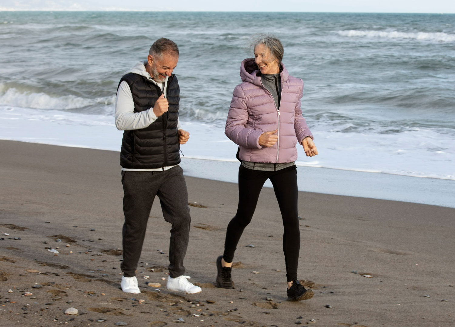 un couple agé court sur la plage - Chondro’Sea